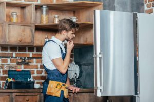 coquitlam refrigerator repair technician diagnosing a leaking fridge